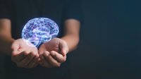 Hands holding glowing digital brain hologram representing artificial intelligence, neuroscience, mental health, innovation and futuristic technology concepts.