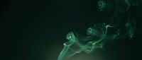 Ethereal green smoke swirls gracefully against a dark background, creating a mystical and atmospheric effect for creative design projects.