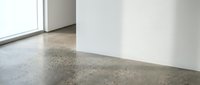 Modern polished concrete floor in minimalist interior with white walls and natural light from window for contemporary home design.