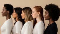 Diverse group of women in profile showing different ethnicities and hairstyles representing beauty diversity and multicultural unity in studio setting.