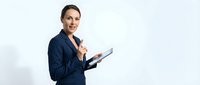 Professional businesswoman in navy suit holding tablet computer against white background for corporate presentations and digital technology concepts.
