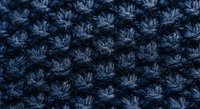 Navy blue knitted wool fabric with textured stitch pattern for cozy winter clothing and textile design projects.