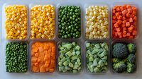 Fresh cut vegetables and frozen corn in meal prep containers arranged in rows, including peas, carrots, broccoli and corn showing healthy food organization.