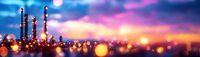 Blurred industrial refinery silhouette against vibrant sunset sky with glowing bokeh lights creating dreamy atmospheric panoramic view. Suitable for energy sector visuals.