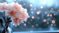 Delicate pink carnations with frost crystals in glass vase against soft bokeh background, perfect for seasonal greeting cards, home decor, and floral design projects.