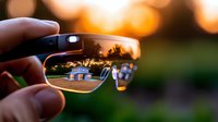 Reflection of suburban houses in sunglasses lens during golden hour sunset, creative perspective photography showing residential neighborhood through eyewear.