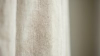Natural linen fabric texture with soft beige color and organic weave pattern for interior design and textile applications.