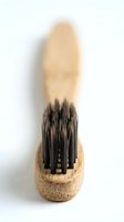 Wooden paintbrush with natural cork handle and black synthetic bristles isolated on white background, ready for design projects and artistic applications.