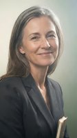 Professional mature businesswoman with gray hair smiling confidently in dark suit jacket holding documents for corporate leadership and executive concepts.