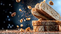 Fresh sliced artisan bread with flying walnuts and crumbs captured in dynamic motion against dark background with bokeh lights. Food photography.