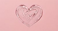 Clear heart-shaped water splash on pink background with droplets and ripples for romantic design projects.