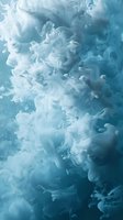 Swirling blue-white smoke creates ethereal abstract patterns against dark background, with delicate wisps and tendrils floating in atmospheric motion.