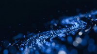 Blue glittering particles with bokeh lights creating magical sparkle effect on dark background for luxury design projects.