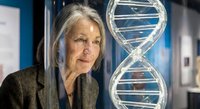 Senior Caucasian female scientist examining DNA double helix model in modern laboratory for genetic research and biotechnology education.
