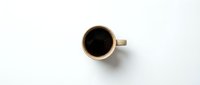 Beige coffee cup with black coffee viewed from above on white background, minimalist flat lay composition for cafe branding and morning beverage concepts.