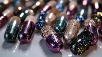 Colorful glittery nail polish bottles with sparkly finishes in purple, green, gold and bronze shades for beauty and cosmetics applications.