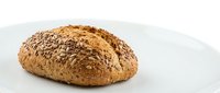 Freshly baked multigrain bread loaf with seeds on white background, artisan bakery product for healthy eating and nutrition concepts.