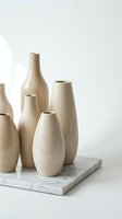 Minimalist beige ceramic vases collection on marble tray against white background for modern home decor and interior design styling projects.