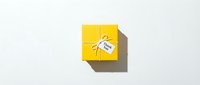 Yellow gift box tied with twine and a thank you tag on white background, top view. Minimalist appreciation concept for holidays.