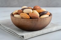 Mixed nuts and almonds in wooden bowl on linen cloth for healthy snacking and cooking ingredients.