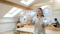 Professional businesswoman interacting with holographic interface technology in modern coworking office space with wooden beams and skylights.