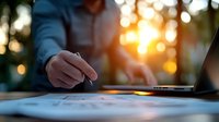 Professional signing document at sunset with golden bokeh background, close up view of hands with pen and paperwork on desk during business meeting.