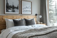 Cozy bedroom interior with wooden headboard, gray and white bedding, winter landscape artwork, and snowy forest view through window. Modern scandinavian design.
