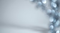 Soft blue bokeh lights creating dreamy atmosphere on light gray background for holiday celebrations and festive decorations.
