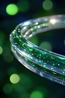 Curved fiber optic cable with green light streaming through transparent tube against dark background with bokeh lights, modern technology concept.