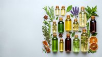 Essential oils collection with fresh herbs, spices and citrus on white background for aromatherapy, natural wellness and spa treatments.