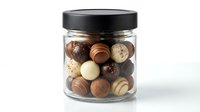 Glass jar filled with assorted luxury chocolate truffles and bonbons on white background for confectionery packaging and gourmet food marketing.