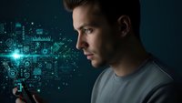 Young Caucasian man in profile gazing at futuristic holographic interface with digital icons and data visualization in dark tech environment.