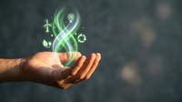 Caucasian male hand holding glowing green renewable energy symbols including wind turbine, solar panel, and gear icons for sustainable power and eco-friendly technology concepts.