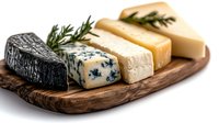 Gourmet cheese board with variety of artisanal cheeses including blue, black rind, and soft white varieties on rustic wooden serving platter garnished with rosemary.