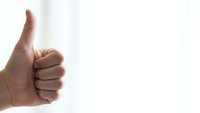 Male hand showing thumbs up gesture on white background for positive feedback and approval concepts.