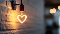 Glowing heart-shaped LED light bulb mounted on brick wall with warm ambient bokeh background creates romantic atmosphere for Valentine's day decor.