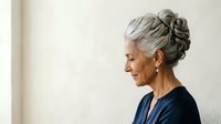 Senior woman with gray hair in updo hairstyle, wearing dark blue top, looking to side in profile against neutral background. Suitable for healthcare, wellness, aging, lifestyle and corporate projects.