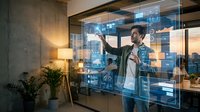 Young Caucasian male professional interacts with a futuristic holographic interface in a modern office, showcasing innovation and digital technology.