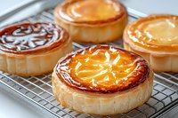 Freshly baked Basque cheesecakes with caramelized golden brown tops cooling on metal rack, showing creamy texture and characteristic burnt surface pattern.