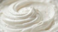 Creamy white swirled texture with smooth flowing curves creating elegant spiral patterns for culinary and beauty applications.