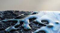 Oil spill rainbow sheen on dark asphalt surface creating iridescent pollution patterns with environmental contamination effects.