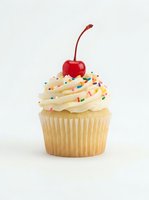 Vanilla cupcake with cream frosting, colorful sprinkles, and red cherry on top, isolated on white background for bakery, dessert, and confectionery design projects.