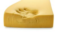 Fresh yellow butter block with creamy texture isolated on white background for culinary cooking baking and food preparation projects.