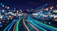 Abstract light trails creating dynamic motion blur effect with colorful streaks and bokeh lights on dark background for technology concepts.
