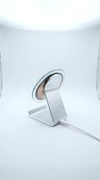 Modern wireless charging stand with sleek metallic design on white studio background for tech accessories and device charging solutions.