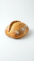 Fresh artisan sourdough bread loaf with golden crust isolated on white background for bakery and food design projects.