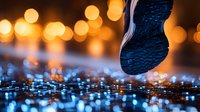 Athletic shoe sole stepping on wet pavement with colorful bokeh lights reflecting on surface creating urban nighttime atmosphere for fitness concepts.