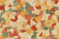 Colorful abstract mosaic pattern with irregular geometric shapes in warm autumn tones of orange, red, green and beige creating artistic textured background.