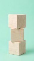 Three stacked wooden blocks in natural light wood tones against a soft mint green background, isolated for design and branding applications.