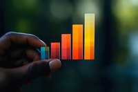 Colorful ascending bar graph chart held up against blurred natural background showing business growth and progress metrics in warm gradient colors.